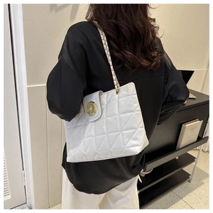 Dettaglio borsa trapuntata bianca con fibbia dorata e tracolla a catena elegante