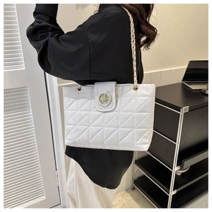 Dettaglio della borsa tote trapuntata bianca con catena dorata e ornamento in metallo