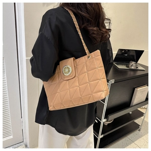 Borsa tote trapuntata kaki con catena dorata mostrata in un ambiente da ufficio