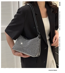 Close-up of sparkling rhinestone moon bag with elegant black strap and silver hardware