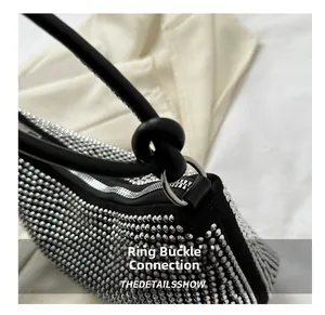 Macro detail of rhinestones on black evening bag with metal ring and knotted handle