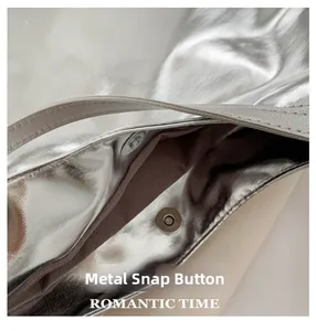 Close-up of the silver metallic tote bag showing its magnetic snap closure and lining