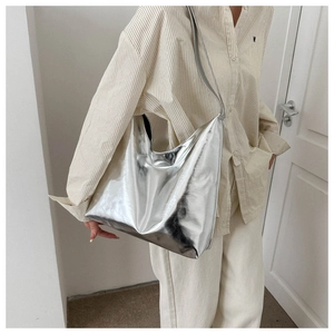 Silver metallic hobo shoulder bag shown on model with minimalist modern style