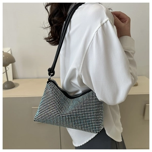 Detail of black rhinestone shoulder bag with shimmering crystals and knotted leather strap
