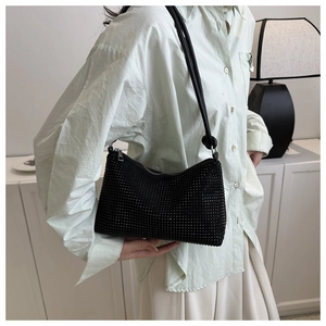 Detail shot of a black rhinestone shoulder bag featuring dense crystals and zipper