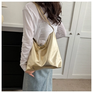 Close-up of a large golden metallic tote bag with sleek shoulder straps for women