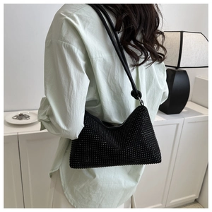 Close-up of black rhinestone hobo bag showing sparkling crystals and leather shoulder strap