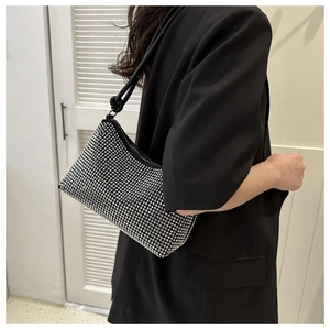 Detail shot of a black shoulder bag with dense sparkling silver rhinestones on a model
