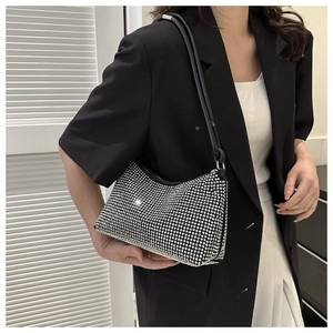 Close-up of sparkling silver rhinestones on a black leather strap shoulder bag detail