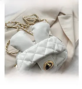 Close-up of white quilted crossbody bag with cute rabbit ears and gold chain strap