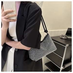 Close-up of sparkling silver rhinestone shoulder bag on a model's shoulder for evening wear