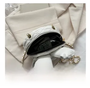 Internal view showing capacity of mini white quilted bunny crossbody bag with gold chain
