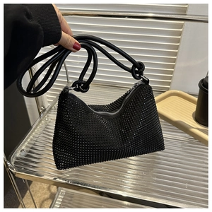 Detail of black rhinestone shoulder bag featuring unique knotted strap and sparkling crystals