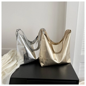 Detail of glossy metallic tote bags in silver and champagne gold on a display stand