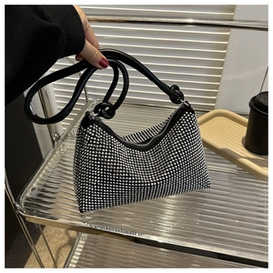 Close-up of silver rhinestone hobo bag with knotted black leather handle and zipper