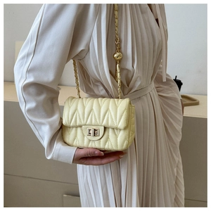 Détail d'un sac en similicuir matelassé en V avec chaîne à billes dorées et fermoir