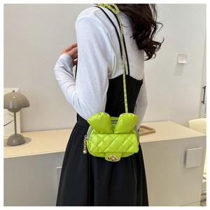 Quilted green rabbit-ear crossbody bag with chain strap shown on a model side view