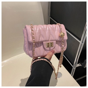Détail du sac en cuir rose matelassé avec bandoulière à chaîne et boule dorée