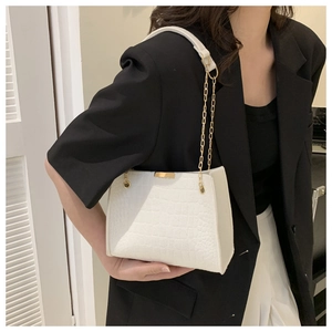 Detailed view of white crocodile pattern shoulder bag with elegant gold metal chain strap