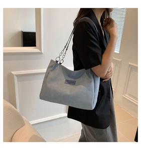 Detail of vintage sky blue tote bag featuring silver chain strap and brand leather label