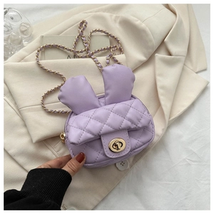 Detail of purple mini quilted bag with rabbit ears and gold twist lock closure