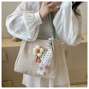 Detailed macro view of beige straw tote bag with V-weave texture and ribbon detail
