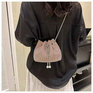 Detailed view of a pink rhinestone bucket bag featuring a pearl drawstring and chain strap