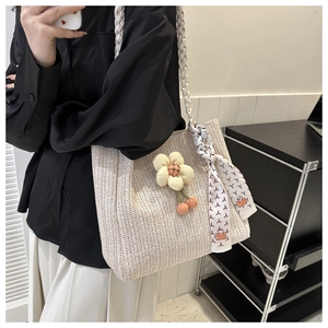 Detail of cream straw tote bag featuring textured V-pattern and colorful printed scarf