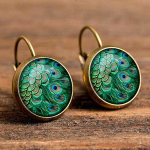 Vintage bronze lever-back earrings with green peacock feather glass gems on wood