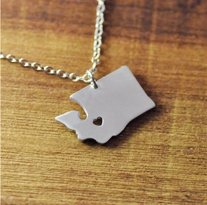 Détail du pendentif argenté carte de Washington avec cœur évidé sur bois