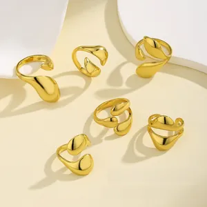 Detailed view of fluid gold adjustable nail rings displayed on a beige aesthetic background