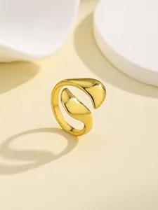 Close-up of polished golden wave ring with smooth flowing curves and a mirror finish