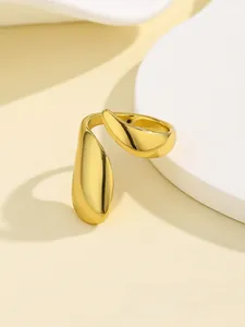 Detailed view of adjustable golden teardrop nail ring with high-polished liquid metal finish