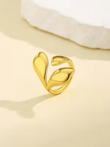 Detail of a polished golden leaf-shaped nail ring featuring a high-gloss metallic finish