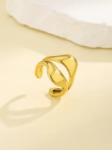 Detail showing elegant gold irregular wave ring on a natural stone prop background