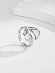 Detailed view of glossy silver asymmetric split ring with sleek minimalist metal finish