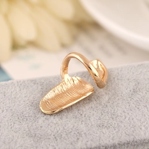 Macro shot of golden alloy nail ring featuring unique vertical wavy texture and sleek finish
