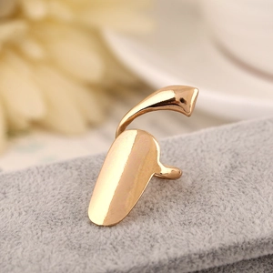 Detailed view of golden metallic nail ring with mirror finish on grey velvet background