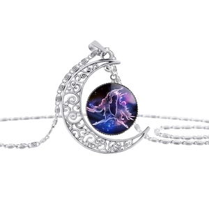 Detail van zilveren halve maan ketting met sterrenhemel edelsteen en engel motief