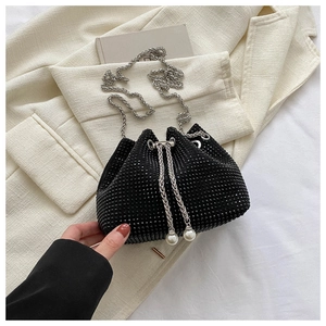 Detail of black rhinestone bucket bag with silver chain and pearl drawstring charms