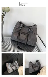 Detail of a large black tote bag with silver chain and vintage leather texture