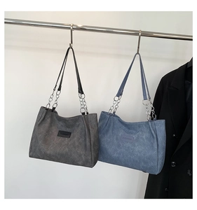 Detail view of large tote bags with matte texture and chain leather shoulder straps