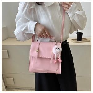 Détail du sac cabas carré rose en cuir avec lanières et charm de sac dessin animé