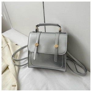 Détail du mini sac à dos argenté métallisé avec deux boucles rondes dorées décoratives
