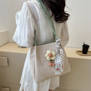 Summer straw tote bag with mint green woven handles and floral ribbon decoration
