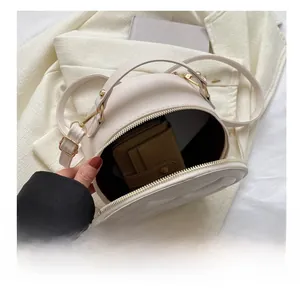 Macro view showing the internal capacity and smooth zipper of the round quilted handbag