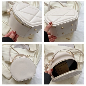 Detail view of round beige PU leather bag with quilted pattern and metal protective studs