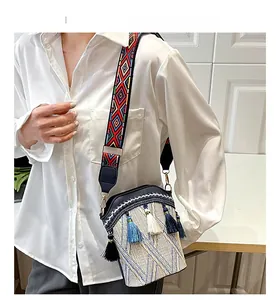 Close-up of ethnic bucket bag with colorful embroidered strap and tiered tassels