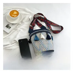 Ethnic woven bucket bag detail with colorful tassels and geometric patterned strap