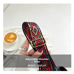 Close-up of adjustable ethnic geometric woven shoulder strap with gold metal buckle